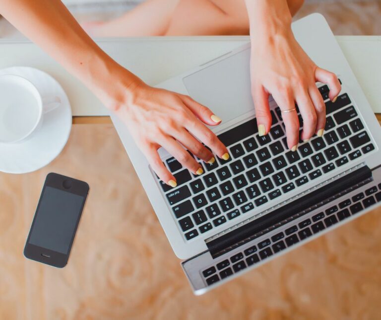 avoir un site internet - mains tapant sur un clavier ordinateur portable - Ysmédia Conseil